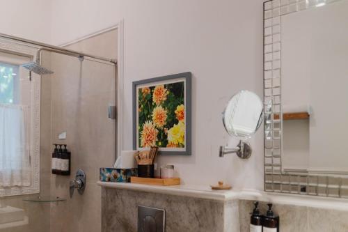 a bathroom with a shower and a painting on the wall at Karma Chalets in Gurgaon