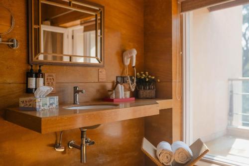 a bathroom with a sink and a mirror at Karma Chalets in Gurgaon