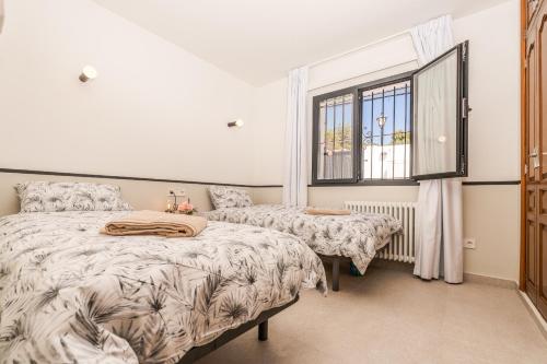 a bedroom with two beds and a window at Casa Buena Vista in Teulada