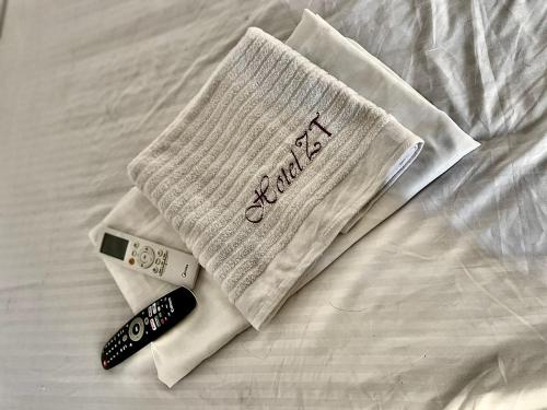 - une serviette et une télécommande pour un lit dans l'établissement Hotel ZT, à Mariquita