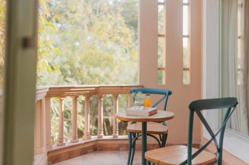 two chairs and a table on a balcony with a window at Karma Chalets in Gurgaon