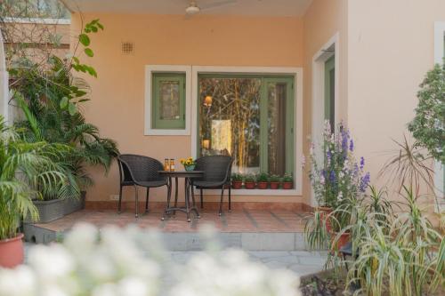 a patio with two chairs and a table with plants at Karma Chalets in Gurgaon