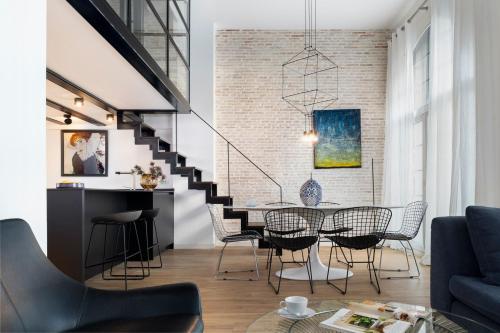 a dining room and living room with a table and chairs at Magno Apartments Sepúlveda in Seville