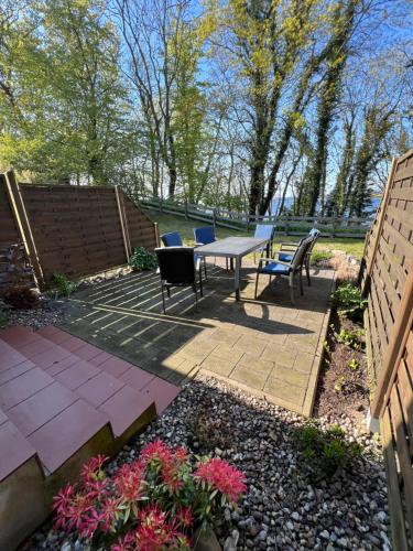 a patio with a table and chairs and flowers at Höfthus 8 in Alt Reddevitz