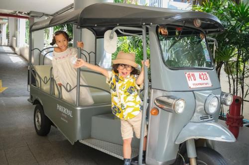 two children are standing in a golf cart at PARKROYAL Suites Bangkok in Bangkok