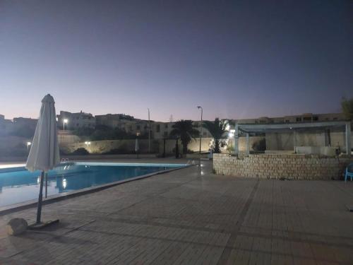 un ombrellone accanto alla piscina di notte di Beachfront Villa 3bedrooms+3bathrooms a El Alamein