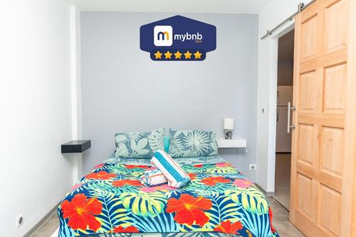 a bedroom with a bed with a colorful comforter at Charming & Connected Studio Papeete near Cruise Terminal in Papeete
