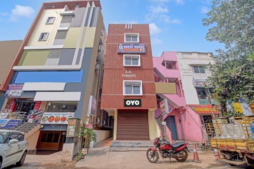 維沙卡帕特南的住宿－OYO AR Guest House，停在前面的一座带摩托车的建筑