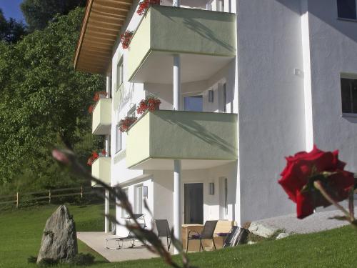 フューゲンにあるLuxurious Apartment in F gen near forestの白い椅子と赤いバラの建物