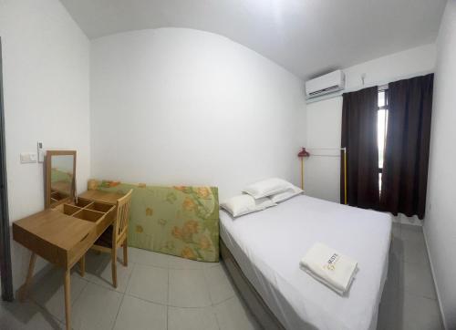 a small room with a bed and a desk and a mirror at 75 Suite (Tower B) in Papar