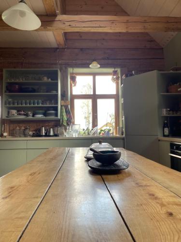 a kitchen with a wooden table with a bowl on it at Ielejas A place for cool living in Vircava