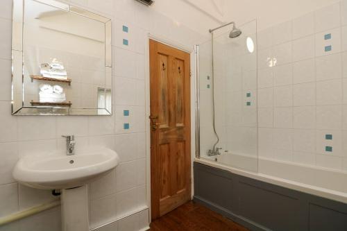 a bathroom with a sink and a shower and a mirror at Incline Cottage in Portreath