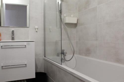 カルノン・プラージュにあるBel appartement spatieuxのバスルーム(シャワー、バスタブ、シンク付)
