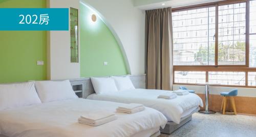 2 camas en una habitación de hotel con ventana en Romance Guest House, en Dalin