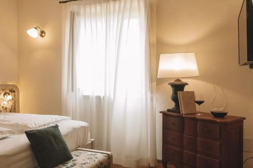 ein Schlafzimmer mit einem Bett und eine Kommode mit einem Fenster in der Unterkunft Wine Resort Campacci in San Gusmè