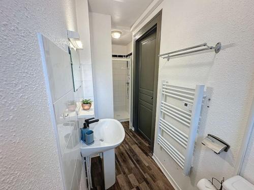 une salle de bain blanche avec un lavabo et une douche dans l'établissement Séjour tout confort à10 minutes du Sanctuaire Lourdes, à Lourdes