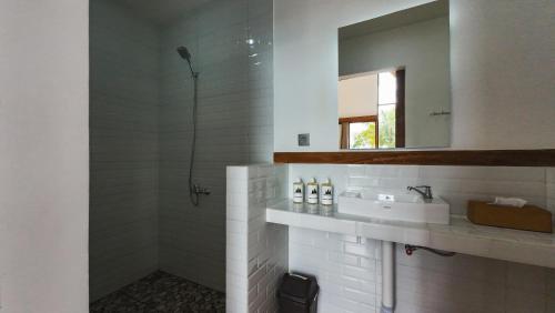 a white bathroom with a sink and a mirror at Catu Glamping Bedugul in Tabanan