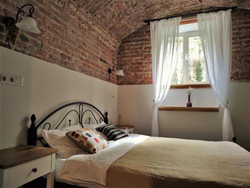 um quarto com uma cama e uma parede de tijolos em Мури Старого Львова em Lviv