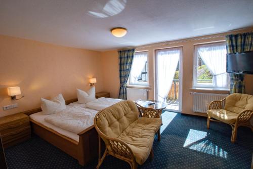 a hotel room with a bed and a chair at Gasthof Braun in Schmallenberg