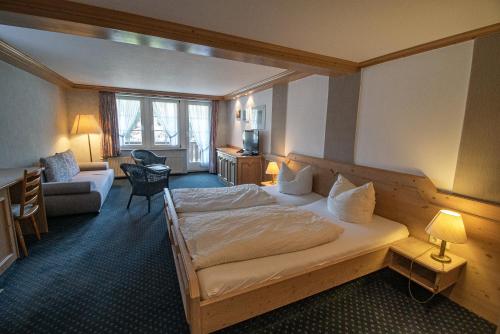 シュマレンベルクにあるガストホフ ブラウンのベッドとリビングルームが備わるホテルルームです。