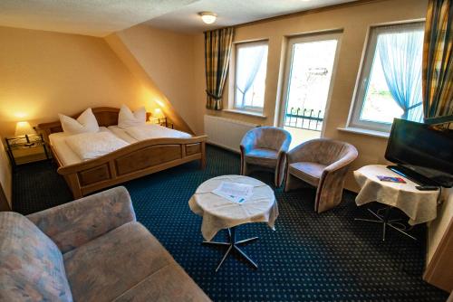a hotel room with a bed and a couch and a tv at Gasthof Braun in Schmallenberg