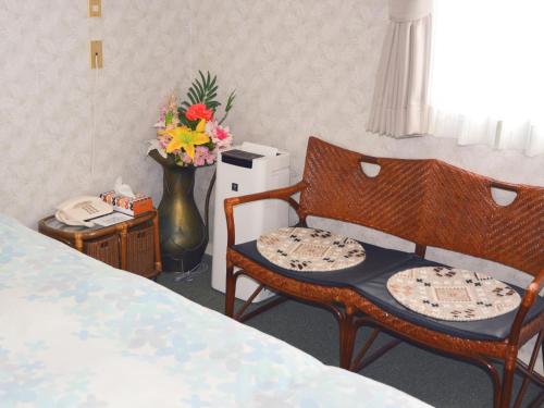 a room with a bed and two chairs and a phone at Nara - Hotel / Vacation STAY 47950 in Nara