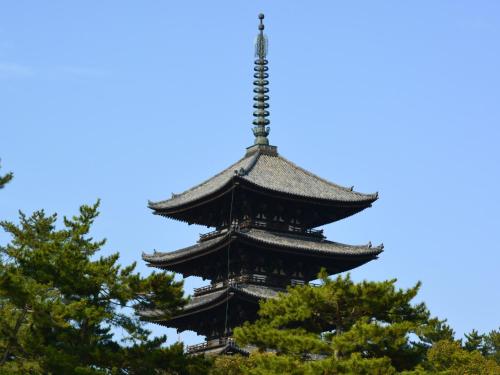 a tall pagoda with trees in the foreground at Nara - Hotel / Vacation STAY 47950 in Nara