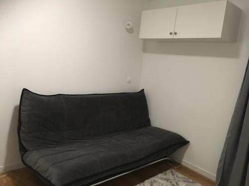 - un canapé noir dans un coin de chambre dans l'établissement Studio - Le Pouliguen, au Pouliguen