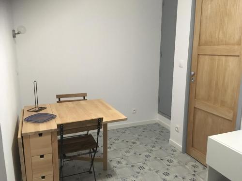 - une table et des chaises en bois dans une chambre avec porte dans l'établissement Studio - Le Pouliguen, au Pouliguen