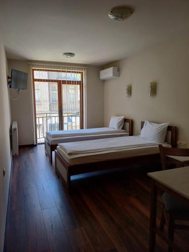 2 camas en una habitación con ventana grande en Семеен хотел МАРС, en Troyan