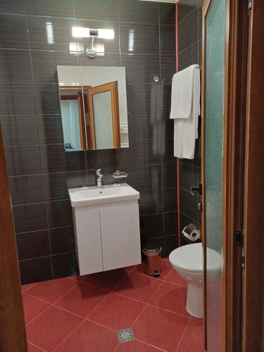 a bathroom with a sink and a toilet and a mirror at Семеен хотел МАРС in Troyan