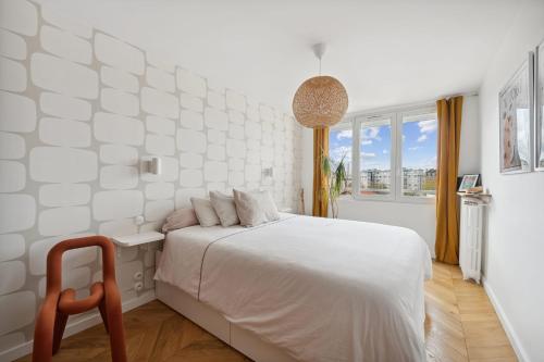 a white bedroom with a bed and a window at Le Michelet - Appartement lumineux in Saint-Ouen