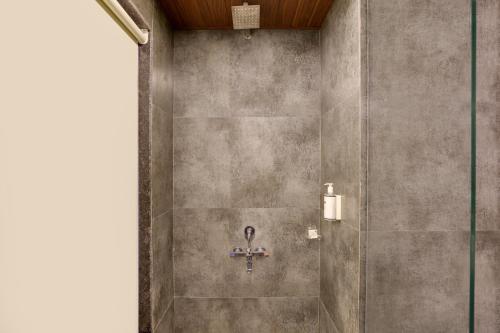 a shower stall with a cross on the wall at Keys Lite by Lemon Tree Hotels Sylvan, Dapoli in Dapoli