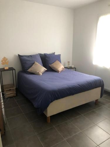 - une chambre avec un lit doté de draps et d'oreillers bleus dans l'établissement Autret, à Guipavas