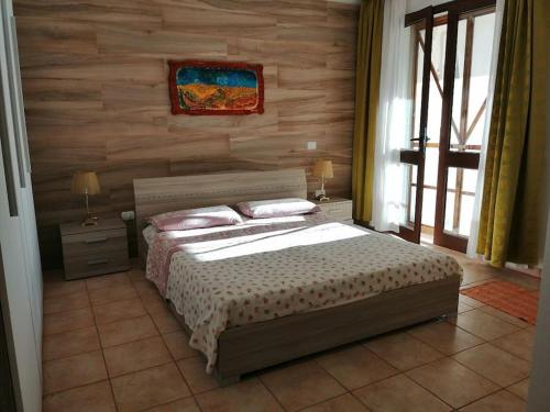 ein Schlafzimmer mit einem Bett und einer Holzwand in der Unterkunft Villetta Serafina Otranto in Otranto
