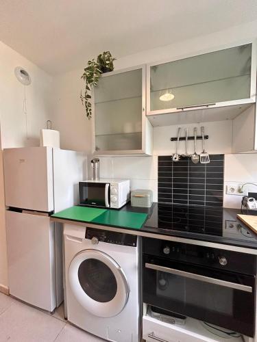 une cuisine avec un lave-linge et un micro-ondes dans l'établissement Appart chaleureux et calme près de PARIS et MÉTRO, à Asnières-sur-Seine