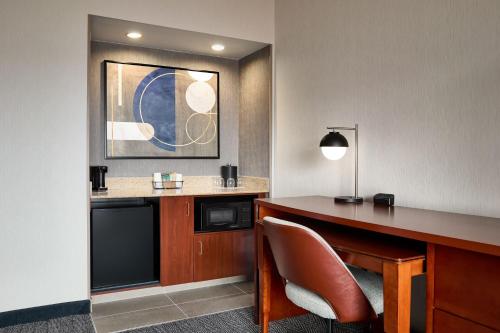 ein Hotelzimmer mit einem Schreibtisch und einem Stuhl in der Unterkunft Courtyard St. Louis Creve Coeur in Creve Coeur
