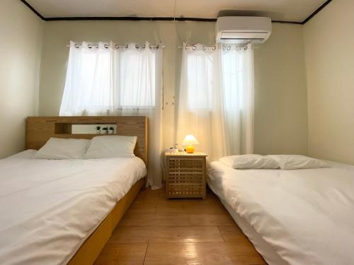 2 camas individuais num quarto com uma janela em Near Shinchon Station Private House em Seul