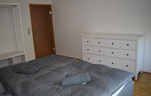 Cette chambre comprend un lit avec deux oreillers et une commode. dans l'établissement Ferienwohnung Rhönmarkt, à Ostheim