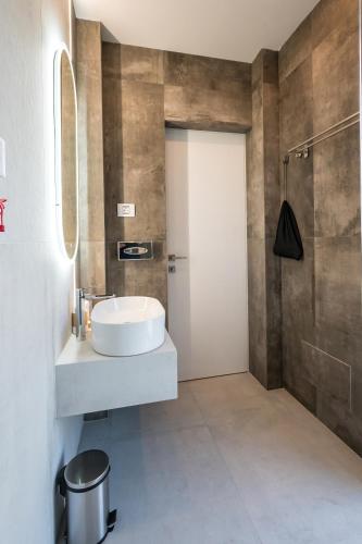a bathroom with a white sink and a shower at ALIVE HOTEL in Oradea