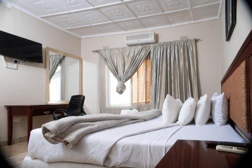 1 dormitorio con cama, escritorio y ventana en Fatmols City Hotel en Ndola