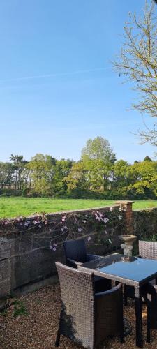 a patio with a table and chairs and a pond at Begonia Cottage in Briston