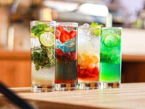 a group of four glasses filled with fruit and vegetables at Nunia Tamansari Hotel in Kumprung