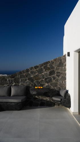 a living room with a couch and a blue wall at Arany Terra in Imerovigli