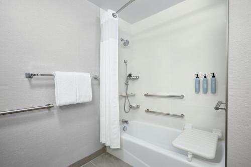 馬里蘭高地的住宿－聖路易斯西港廣場萬怡酒店，带浴缸、卫生间和盥洗盆的浴室