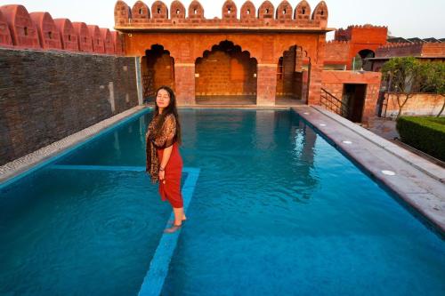 une femme debout dans un bassin d'eau bleue dans l'établissement Pukhraj Garh, à Jodhpur