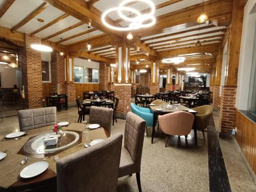 un restaurante con mesas y sillas en una habitación en Hotel Chautari pvt ltd, en Nagarkot