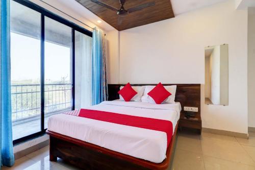 a bedroom with a large bed with red pillows at OYO Comfort lodging and boarding in Kalyan
