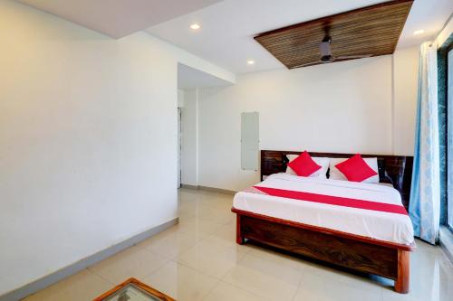 a bedroom with a large bed with red pillows at OYO Comfort lodging and boarding in Kalyan