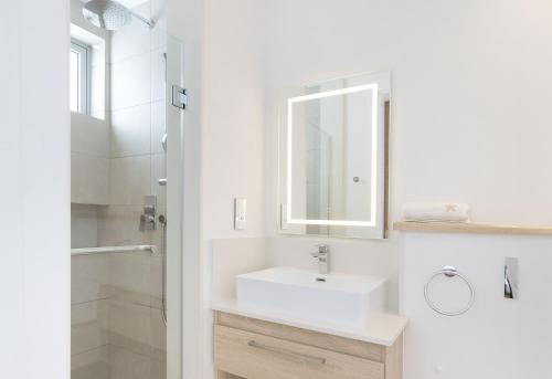 a white bathroom with a sink and a shower at Ocean Grand Gaube by Host Agents in Grand Gaube